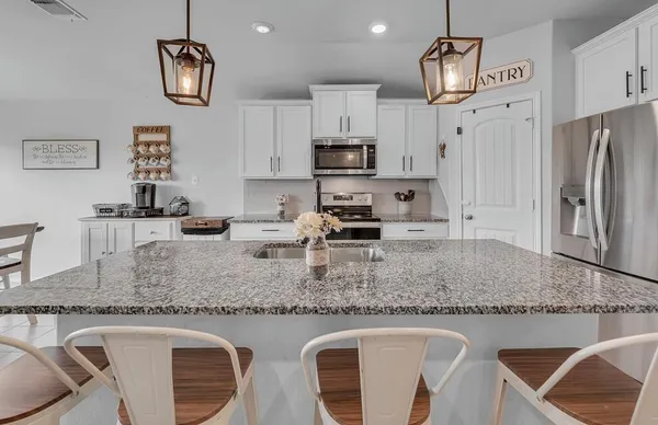 a kitchen with stainless steel appliances granite countertop a sink a stove top oven a counter space and cabinets