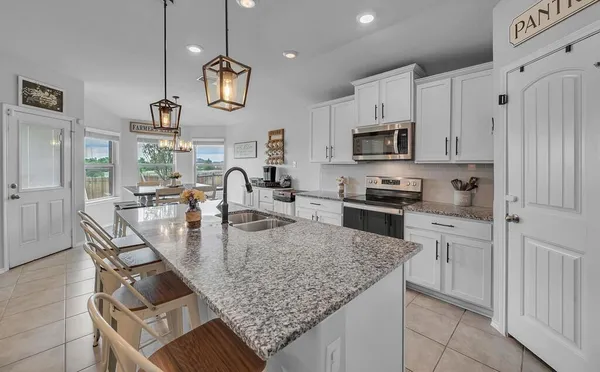 a kitchen with stainless steel appliances granite countertop a sink refrigerator and cabinets
