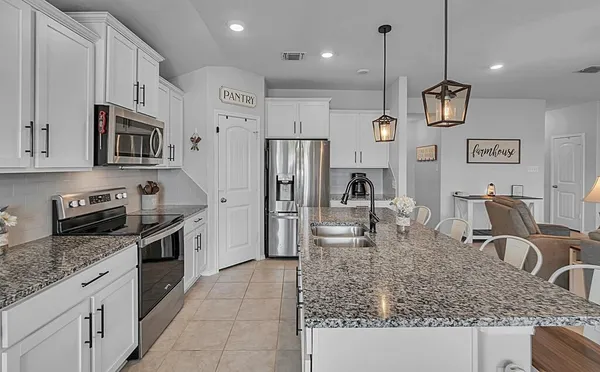 a kitchen with stainless steel appliances granite countertop a sink refrigerator and microwave