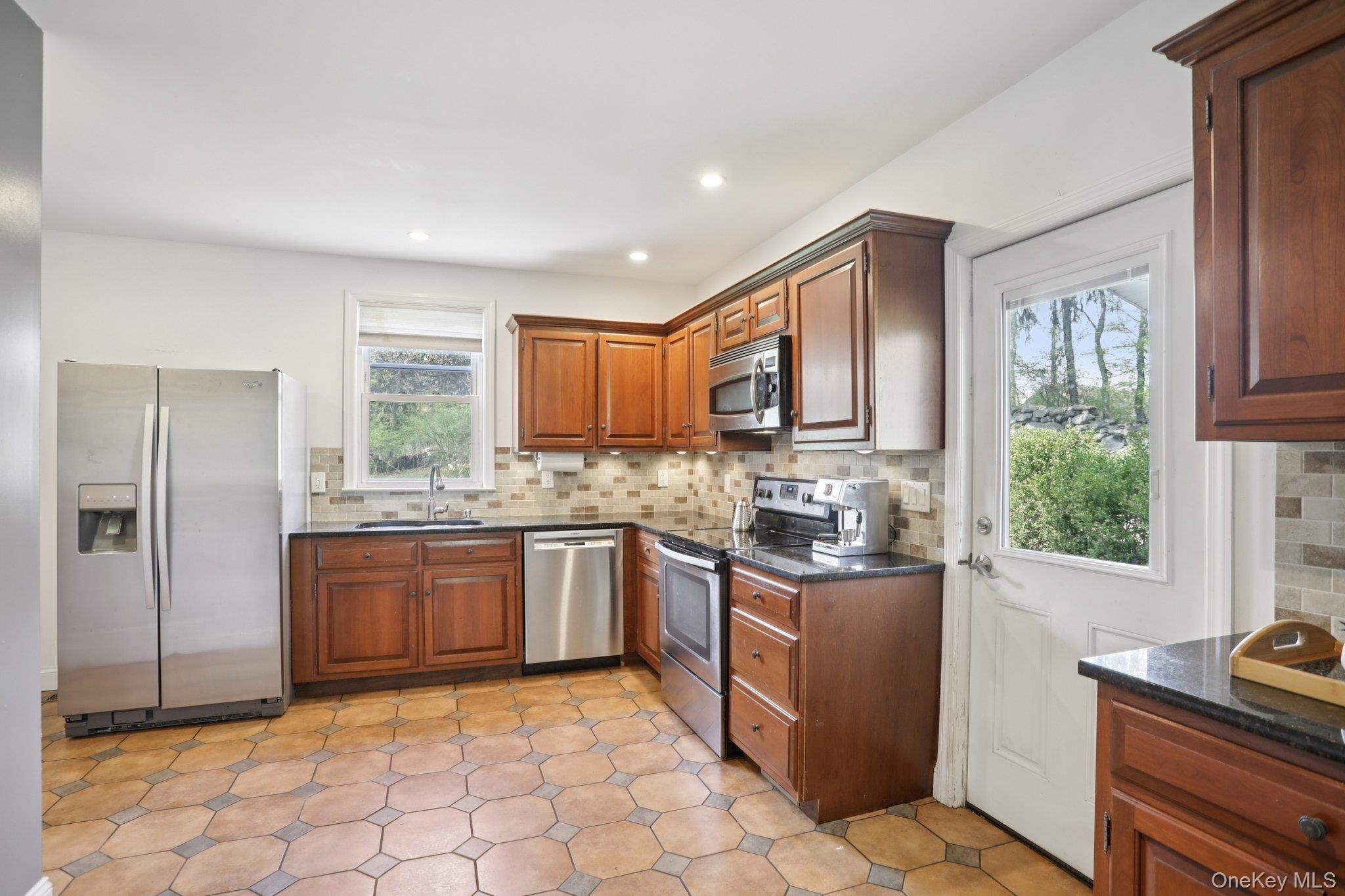 101 Spring Valley Road Ossining, NY 10562 - Photo 16 of 39 a kitchen with stainless steel appliances granite countertop a stove top oven sink and cabinets