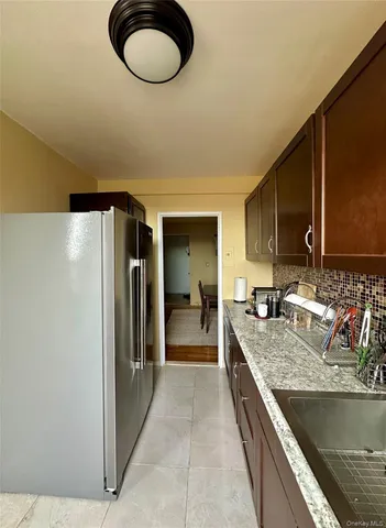 a kitchen with stainless steel appliances granite countertop a sink and a refrigerator