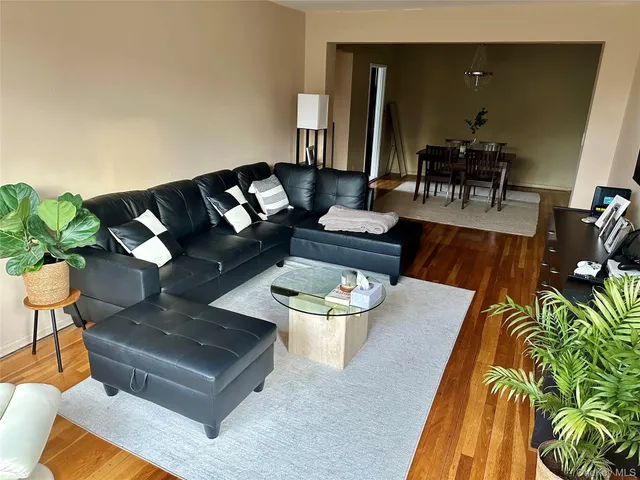 a living room with furniture and a dining table with garden view
