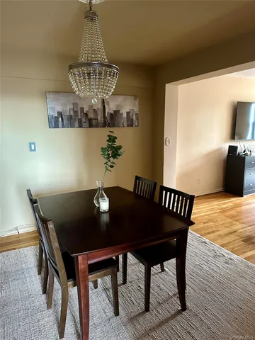 a view of a dining room with furniture a chandelier and wooden floor