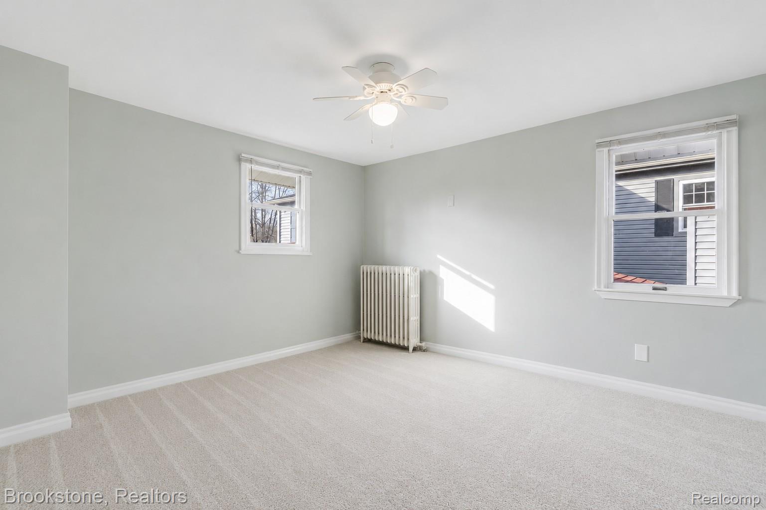 2230 Elm Street Algonac, MI 48001 - Photo 42 of 59 Unfurnished room featuring light colored carpet, radiator, and a ceiling fan