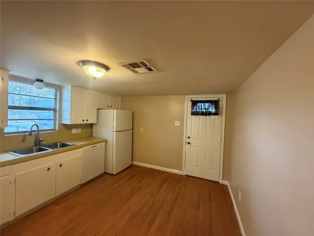 a kitchen with a sink and wooden floor
