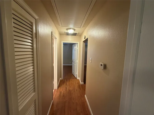 a view of hallway with stainless steel appliances wooden floor