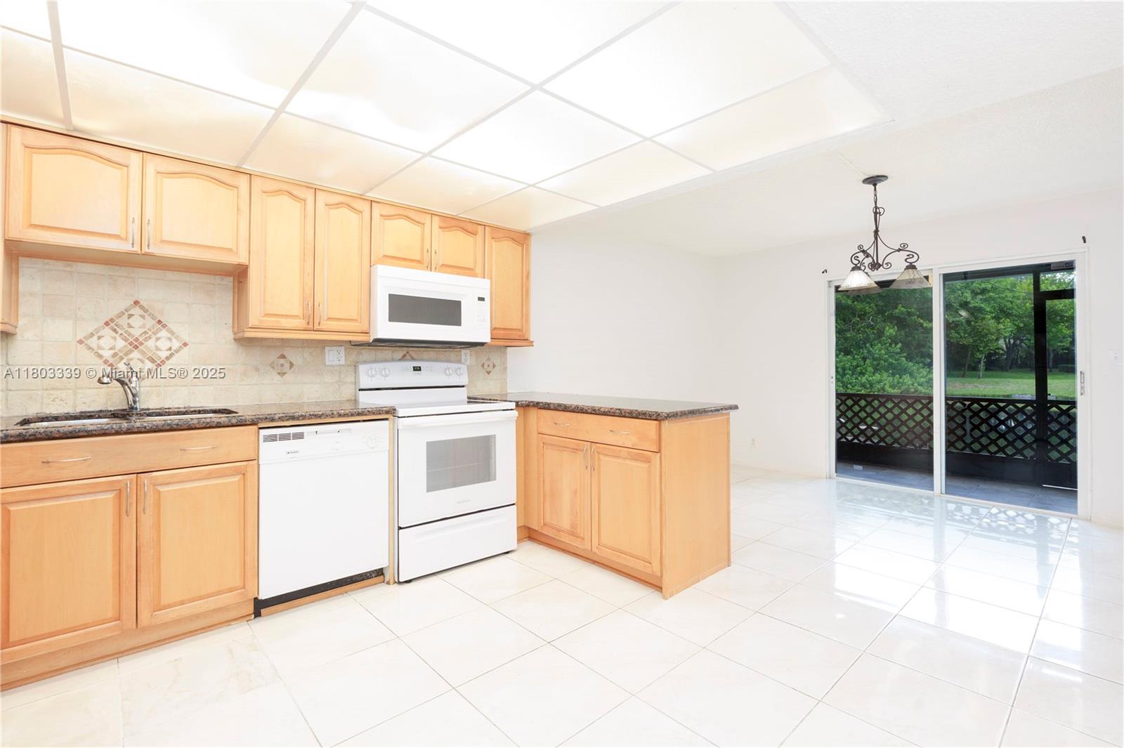 611 North University Drive, Unit 3 Plantation, FL 33324 - Photo 12 of 23 a kitchen with stainless steel appliances granite countertop a stove a sink and a microwave