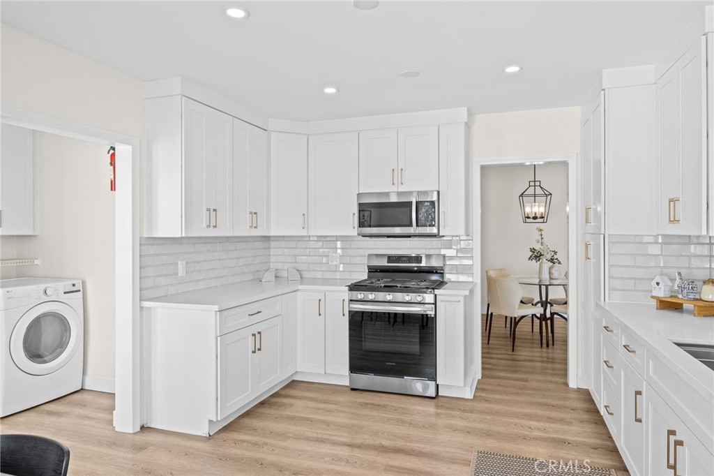 3045 Scott Road Burbank, CA 91504 - Photo 12 of 39 a kitchen with stainless steel appliances granite countertop a stove top oven a sink dishwasher and a refrigerator with wooden floors
