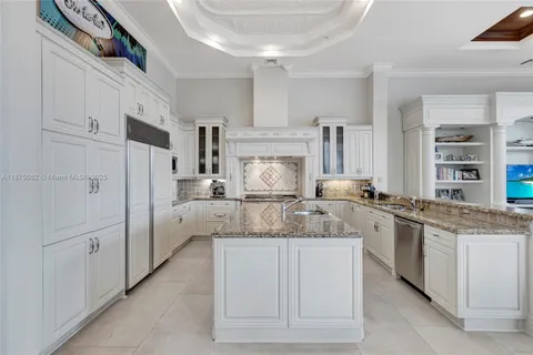 a kitchen with granite countertop cabinets a stove a dining table and chairs