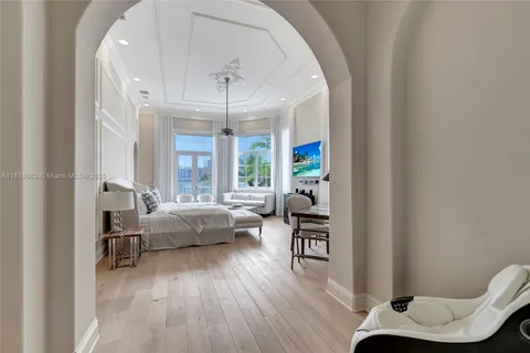 a bedroom with a bed couch and a chandelier