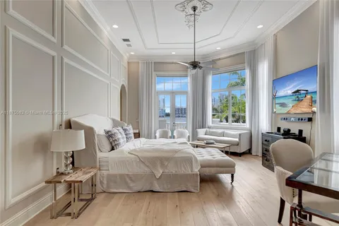 a bedroom with a bed window and a chandelier