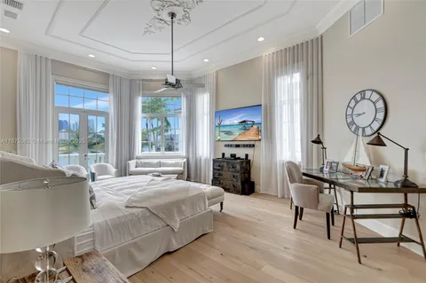 a spacious bedroom with a bed a couch and a flat screen tv