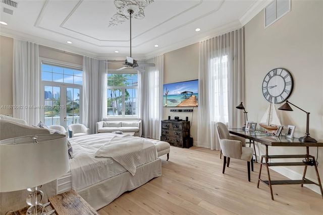 a spacious bedroom with a bed a couch and a flat screen tv