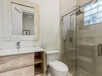 a bathroom with a granite countertop double vanity and a mirror
