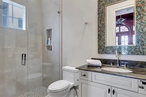 a bathroom with a granite countertop sink a toilet and shower