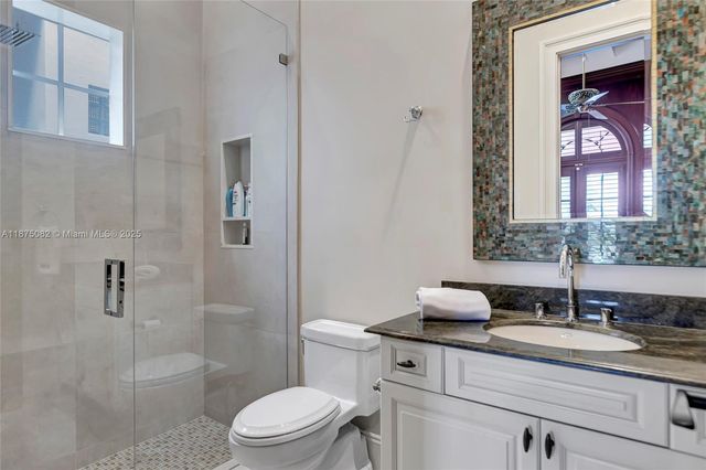 a bathroom with a granite countertop sink a toilet and shower