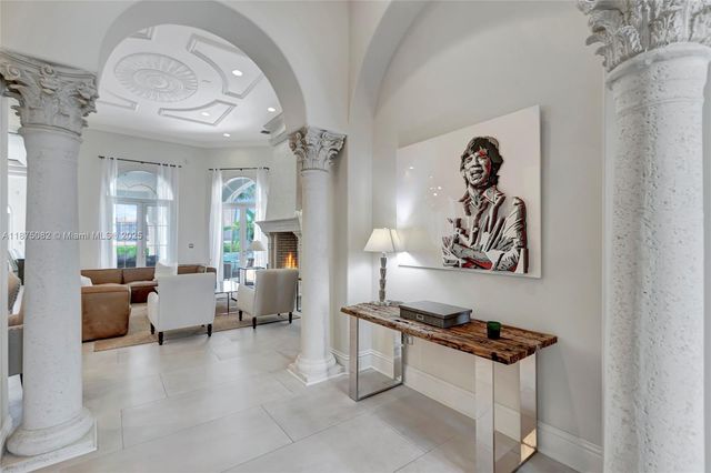 a living room with furniture kitchen view and large windows