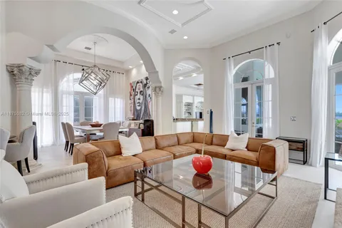 a living room with furniture a fireplace and a chandelier