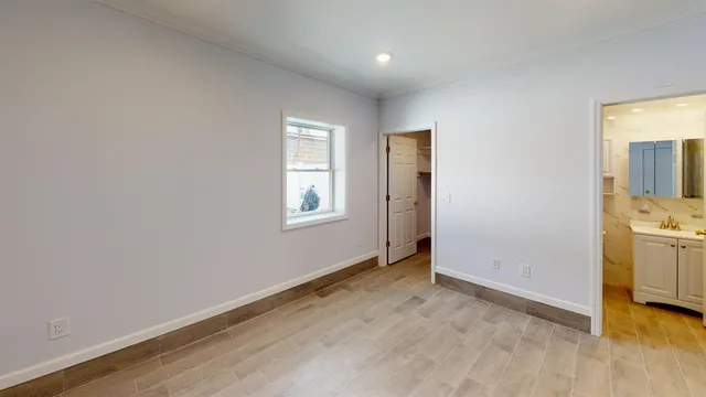 an empty room with a window and wooden floor