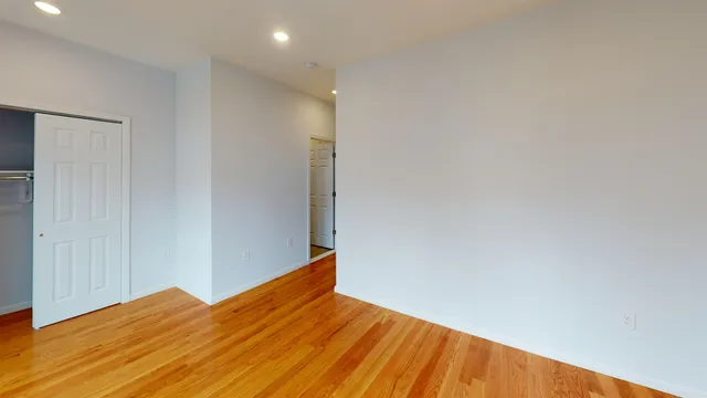 a view of empty room with wooden floor