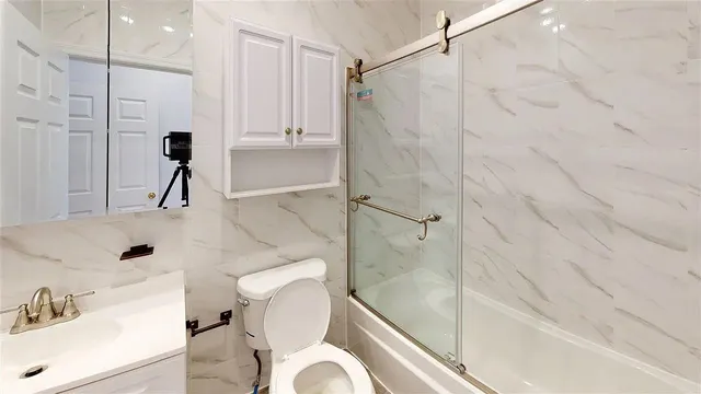 a bathroom with a sink a toilet and shower