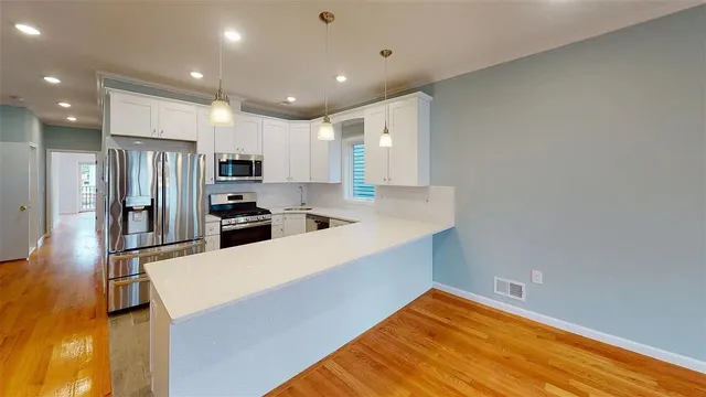 a kitchen with stainless steel appliances a refrigerator and a stove top oven