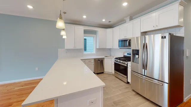 a kitchen with stainless steel appliances granite countertop a refrigerator sink and stove