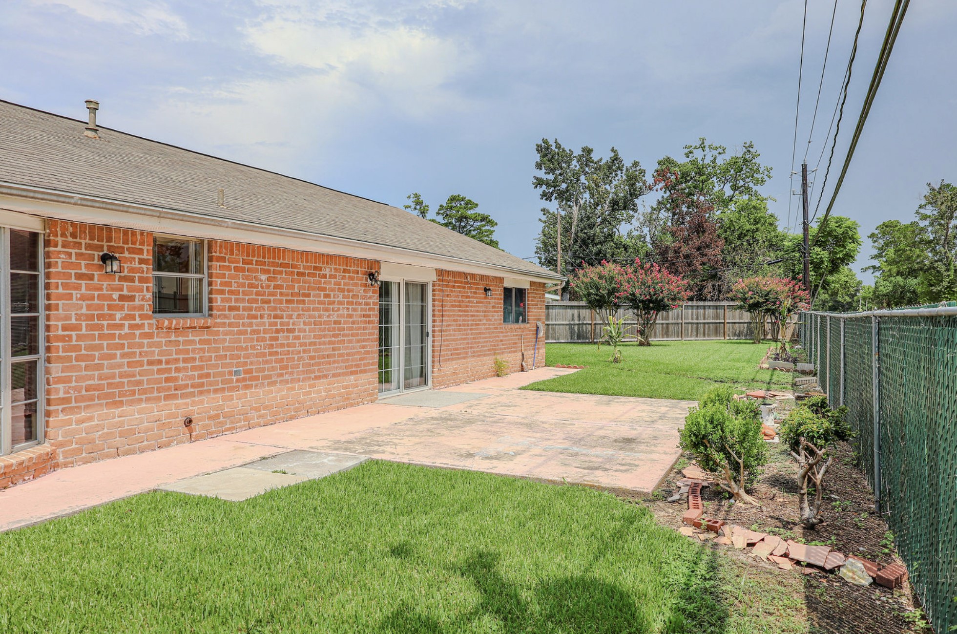 722 Canna Street Channelview, TX 77530 - Photo 9 of 10 a backyard of a house with plants and large tree