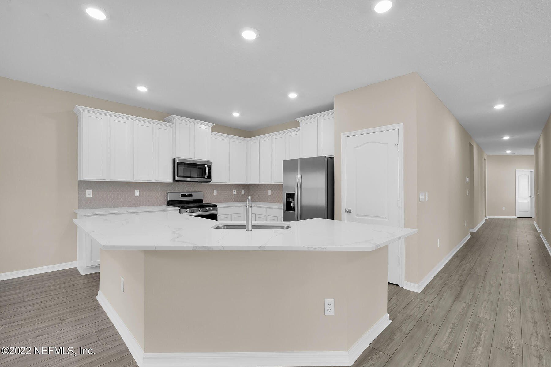 64 Falcon Ridge Road St. Augustine, FL 32084 - Photo 4 of 11 a large kitchen with stainless steel appliances granite countertop a sink a stove a refrigerator a center island with wooden floor