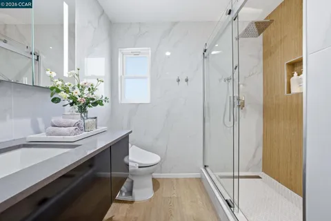 a bathroom with a sink toilet a mirror and shower