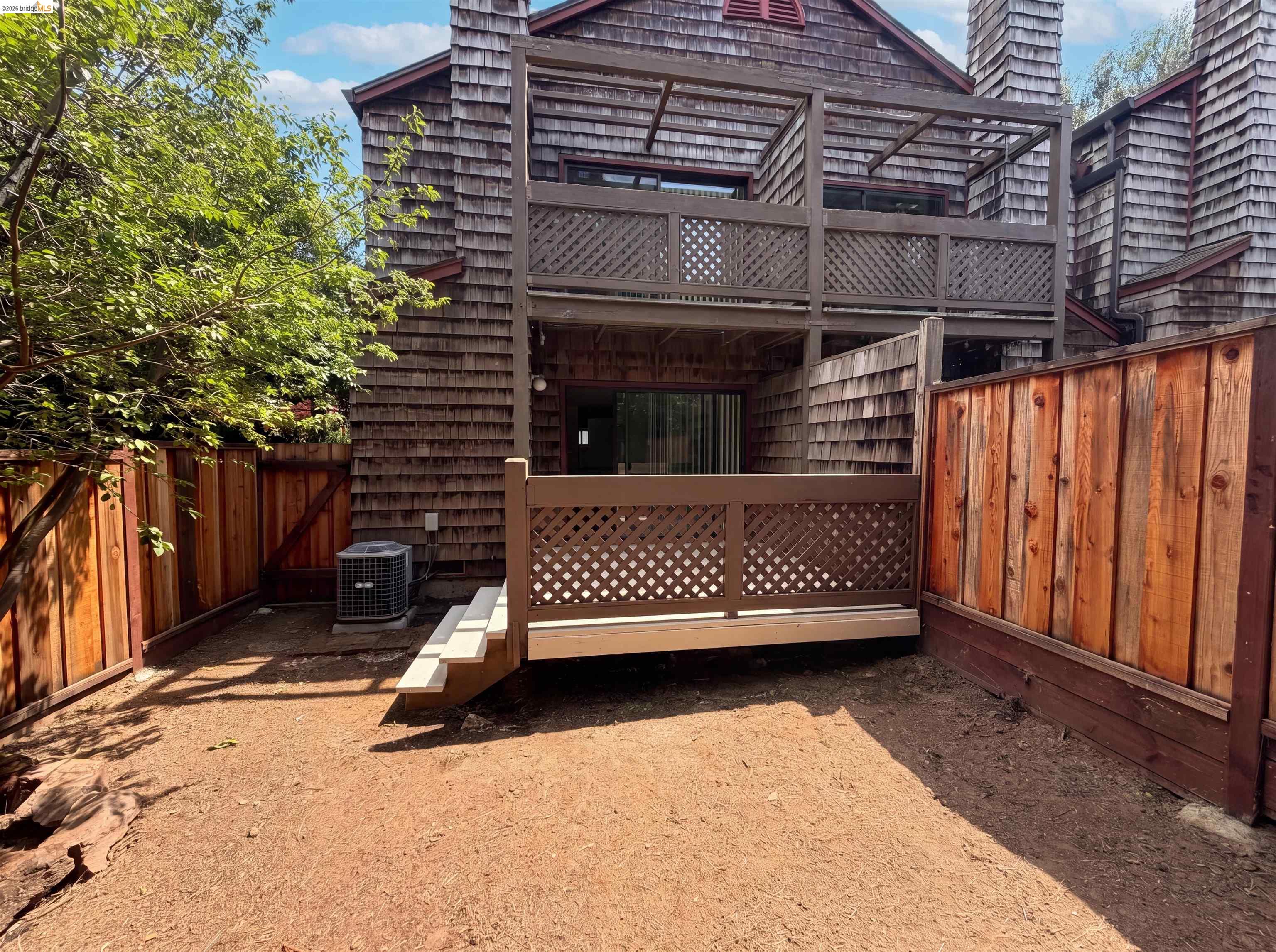 1555 Hecker Pass Road, Unit C101 Gilroy, CA 95020 - Photo 5 of 18 Private outdoor space featuring a ground-level patio with steps, a wood lattice railing, and perimeter fencing