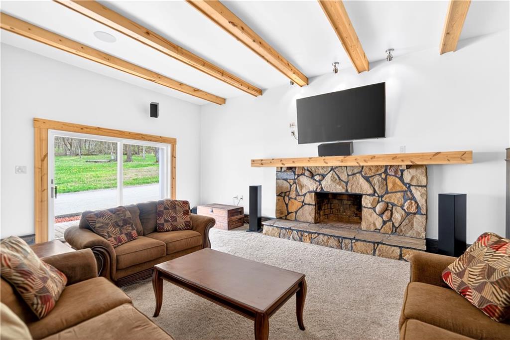 199 Lower Harmony Road Prospect, PA 16052 - Photo 14 of 49 11'ceilings and the stone surround fireplace highlight this room. Seller has never used the fireplace. The 70" TV stays with the house.