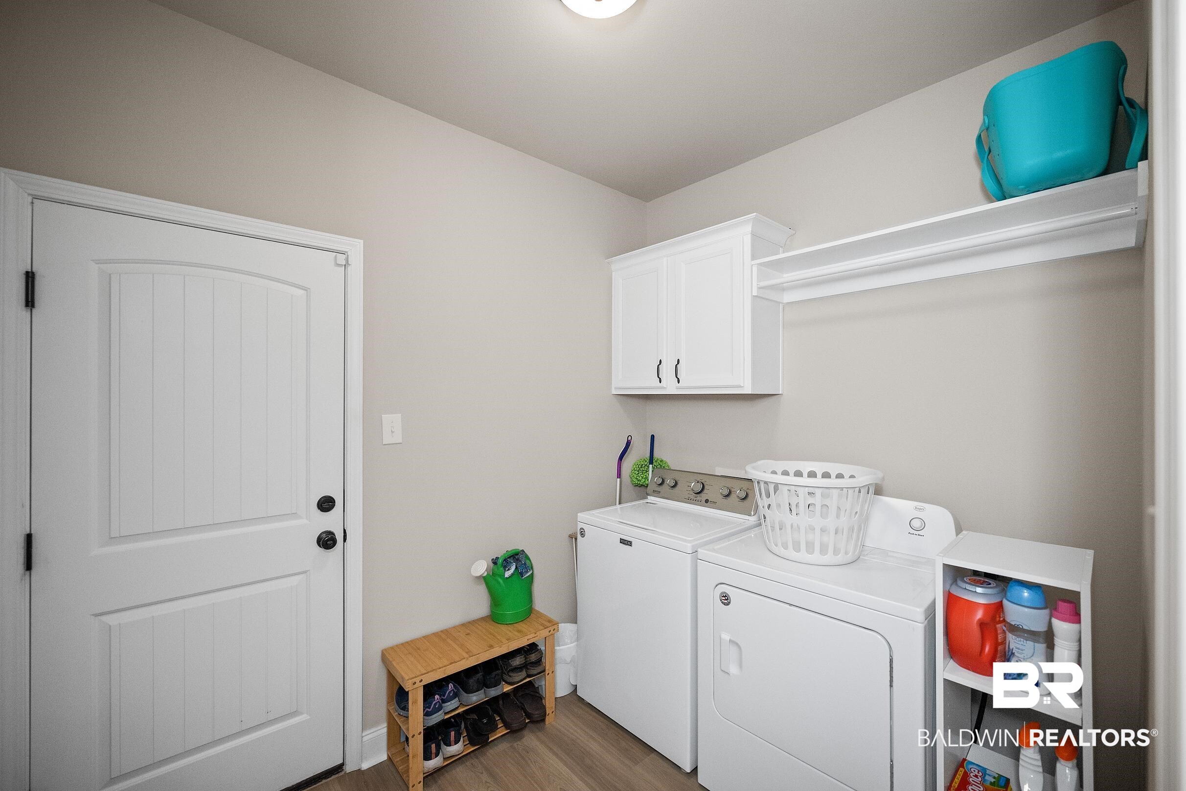 1077 Stella Road Foley, AL 36535 - Photo 14 of 27 Laundry area with washing machine and dryer, dark wood finished floors, and cabinet space
