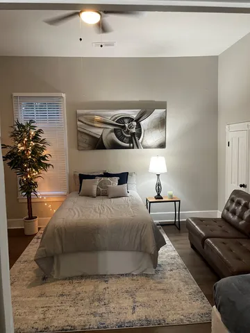 a bedroom with a bed and a potted plant