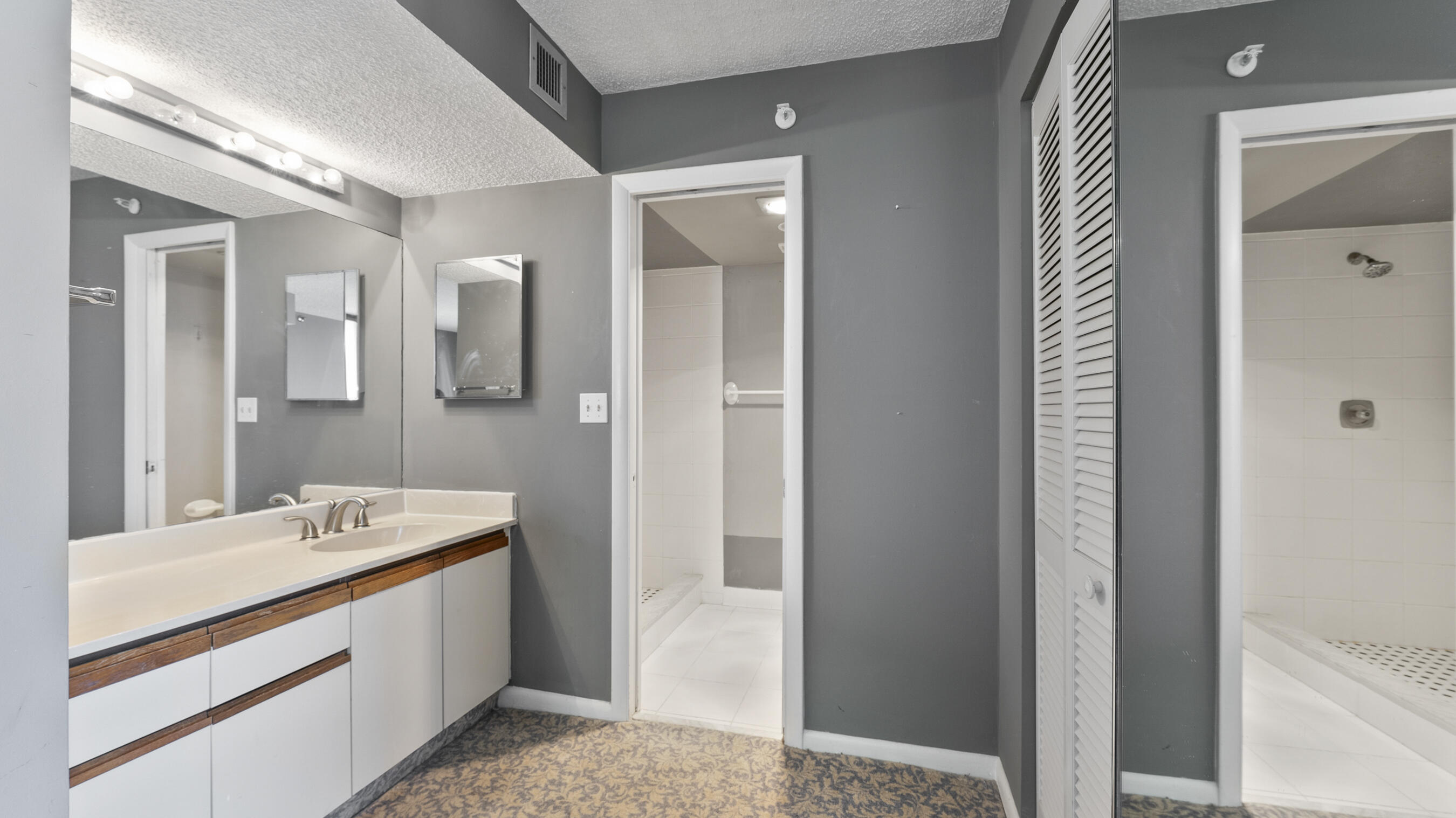 300 Ocean Trail Way, Unit 401 Jupiter, FL 33477 - Photo 11 of 41 a bathroom with a sink a mirror and a shower