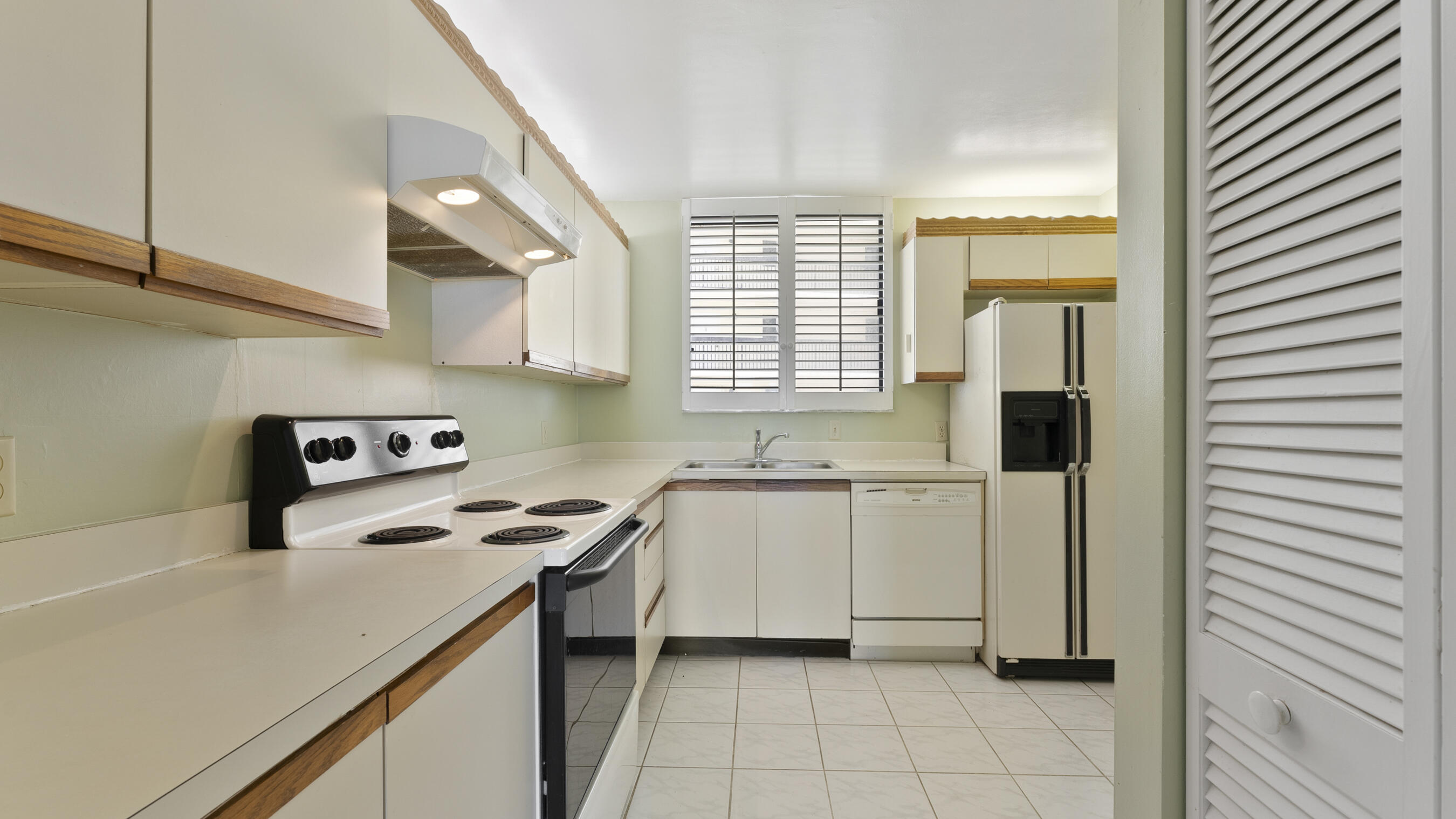 300 Ocean Trail Way, Unit 401 Jupiter, FL 33477 - Photo 17 of 41 a kitchen with a stove a sink and a refrigerator