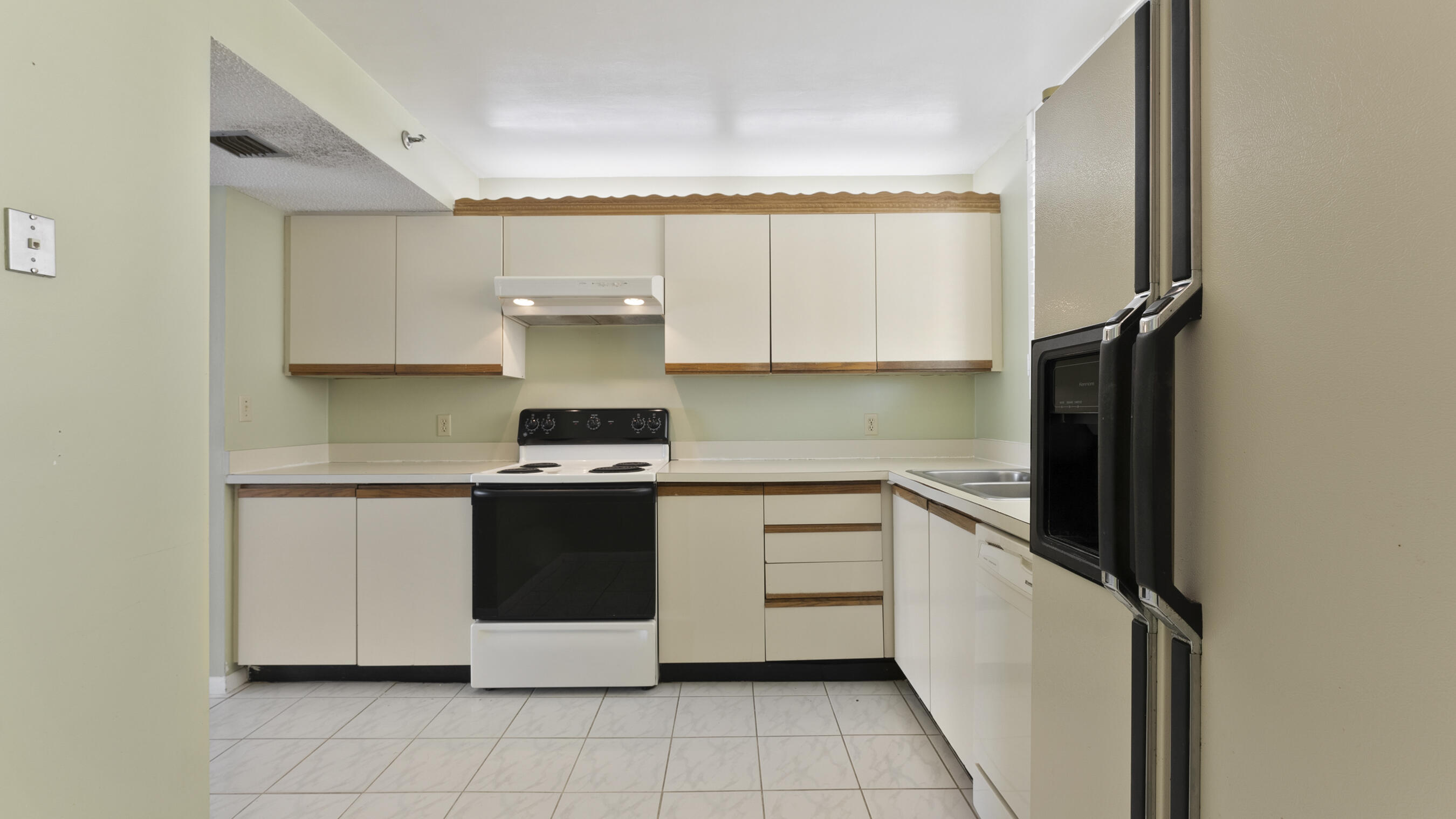 300 Ocean Trail Way, Unit 401 Jupiter, FL 33477 - Photo 18 of 41 a kitchen with a stove top oven sink and cabinets
