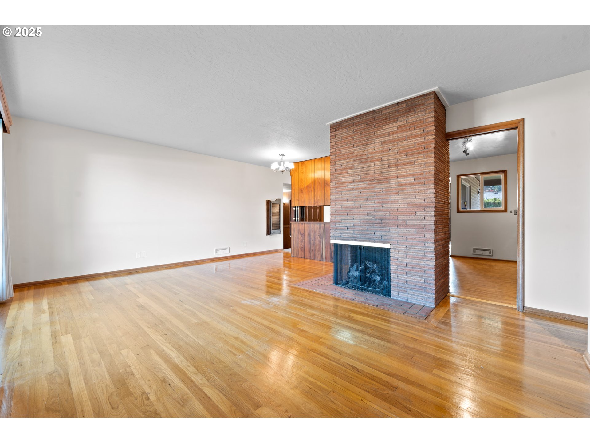 12342 Northeast Knott Street Portland, OR 97230 - Photo 6 of 40 a view of empty room with wooden floor and fireplace
