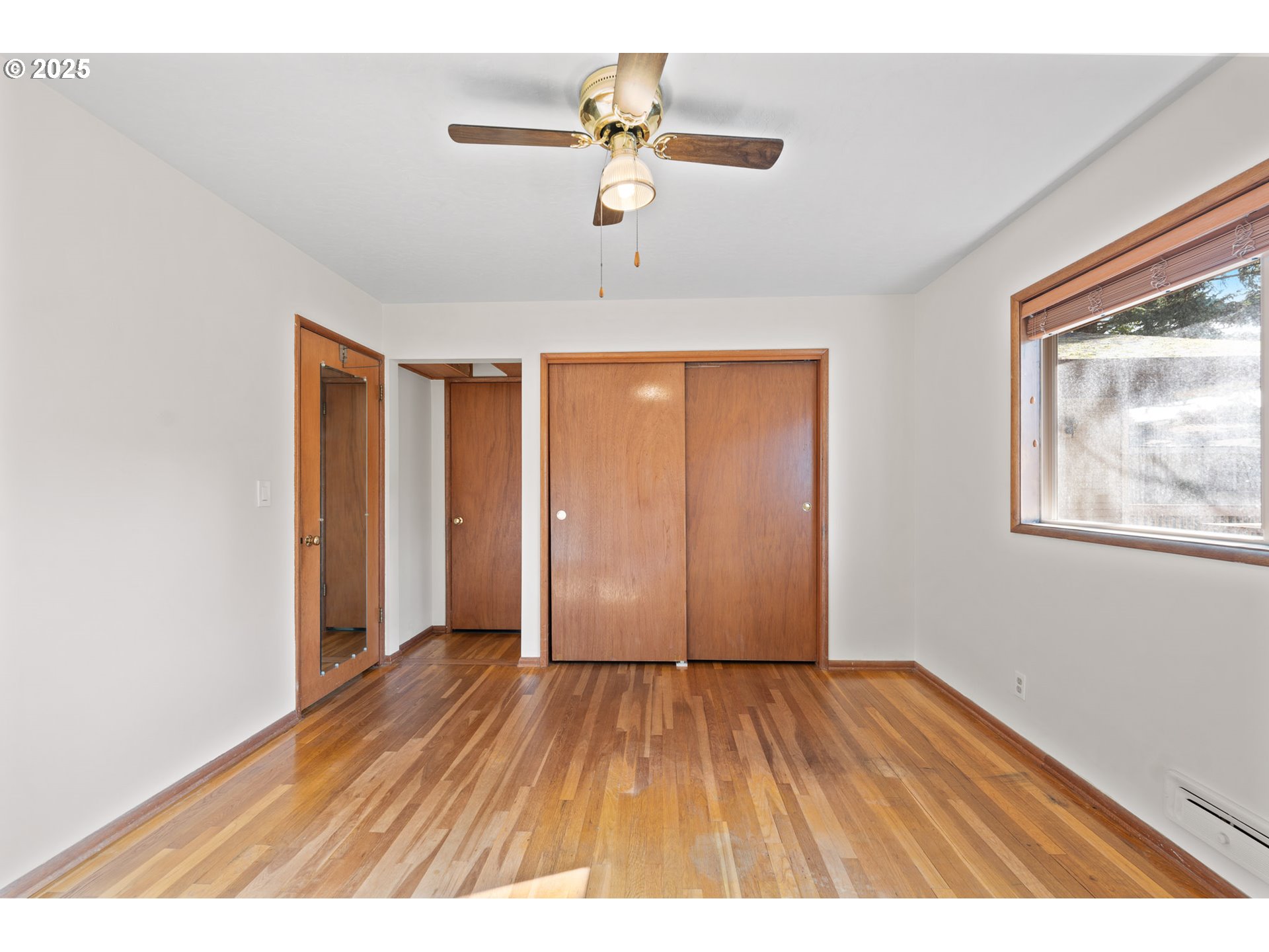 12342 Northeast Knott Street Portland, OR 97230 - Photo 9 of 40 a view interior of a house with wooden floor a ceiling fan and window