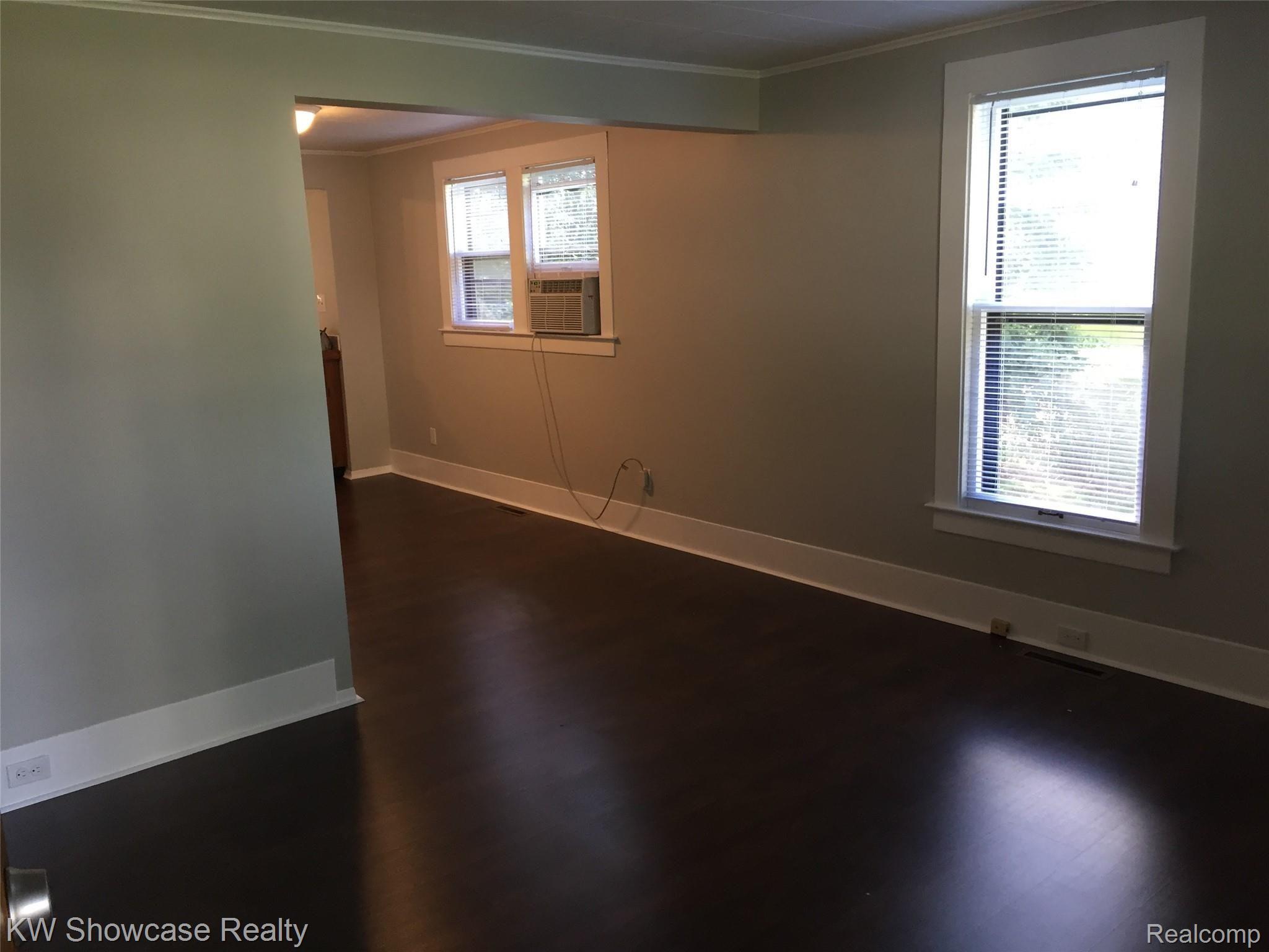129 Ruth Avenue Pontiac, MI 48341 - Photo 5 of 36 Living Room to DR area. All newer laminate walnut color flooring through out entry level.