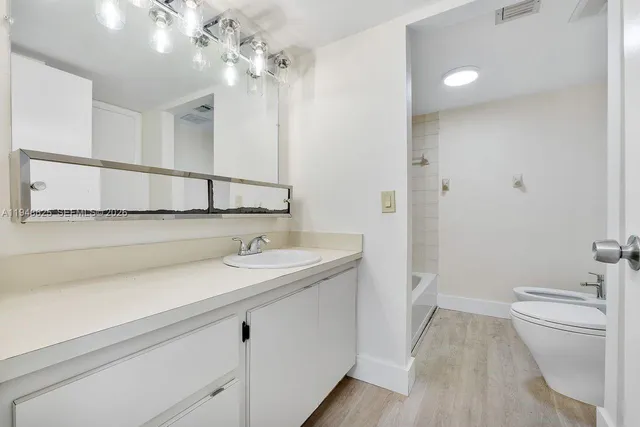 a white toilet sitting next to a bath tub