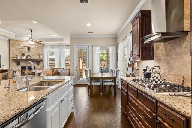 a kitchen with stainless steel appliances granite countertop a sink stove and cabinets
