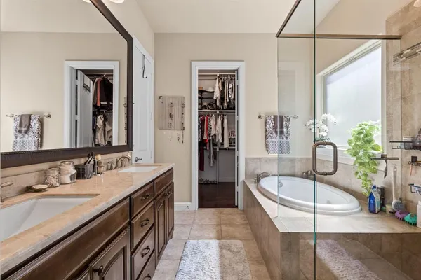 a bathroom with a tub a sink and mirror