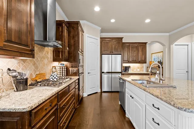 a kitchen with stainless steel appliances granite countertop a sink stove and refrigerator