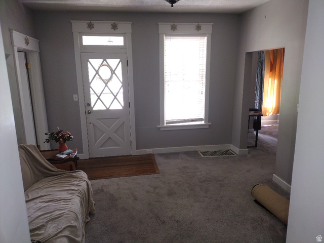 157 West 500 South Logan, UT 84321 - Photo 16 of 38 Entryway featuring a decorative transom window, patterned glass door, and neutral gray wall tones