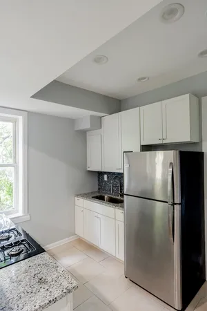 a kitchen with stainless steel appliances granite countertop a refrigerator sink stove and cabinets