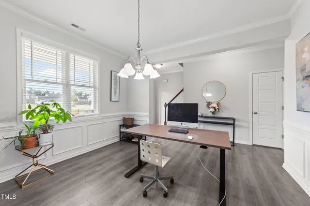 a workspace with furniture a potted plant and wooden floor