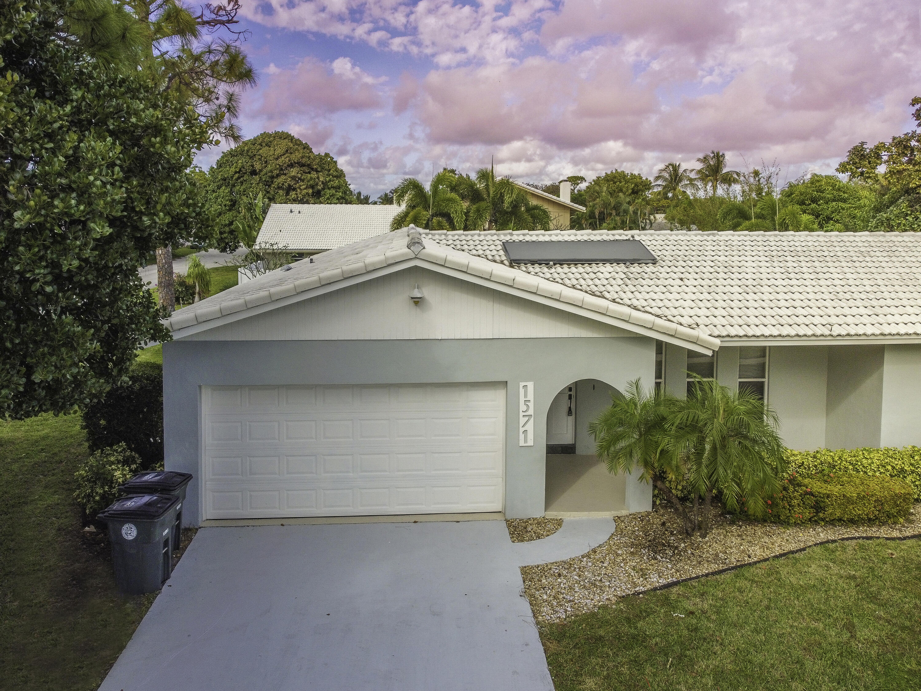1571 Southwest 13th Drive Boca Raton, FL 33486 - Photo 18 of 21 a front view of a house with a yard and garage