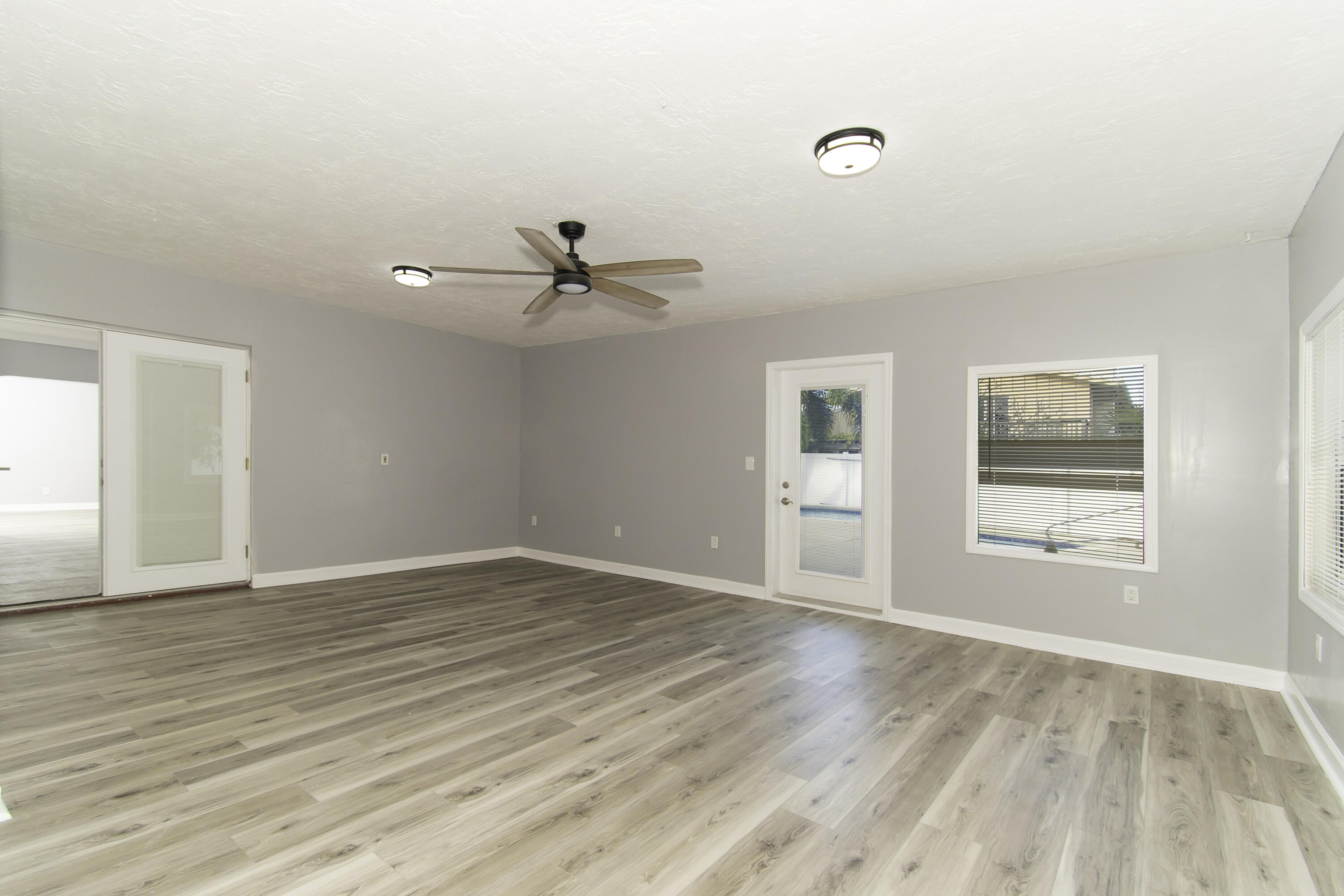 1571 Southwest 13th Drive Boca Raton, FL 33486 - Photo 21 of 21 a view of an empty room with wooden floor and a window