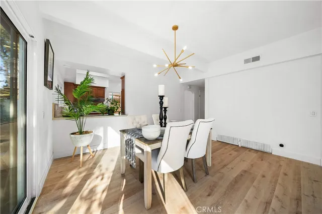 a dining room with furniture potted plants and wooden floor